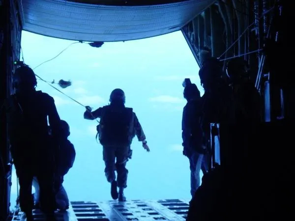 Paratroopers silhouetted at the open ramp of an aircraft
